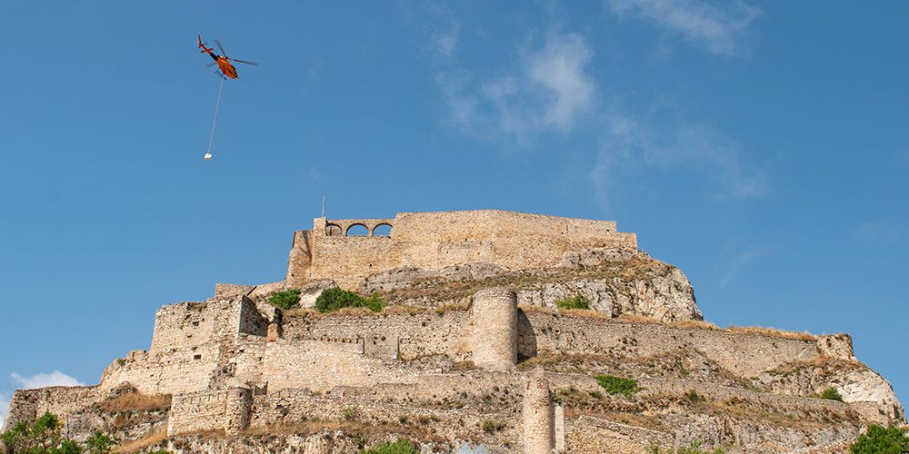 Un helicòpter puja el material a la plaça d’armes per continuar amb les obres al castell de Morella